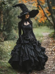 a woman in a black dress and hat walking down a path