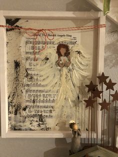 an angel is sitting on top of a shelf next to a clock and star decorations
