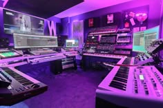 the control room is full of many electronic devices and sound equipment, all lit up with purple lighting