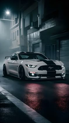 a white mustang parked on the street at night