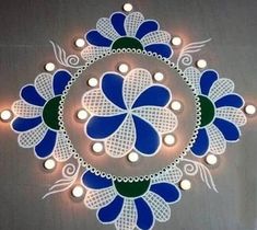 a circular design with blue, green and white flowers on the center is surrounded by small lights