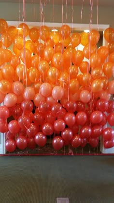 orange and red balloons are hanging from the ceiling