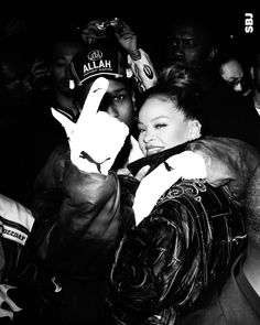 two people standing next to each other in front of a crowd holding up their hands