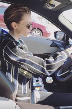 a woman sitting in the driver's seat of a car