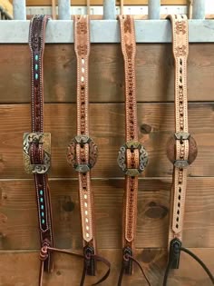 three different types of horse bridles hanging on a wall