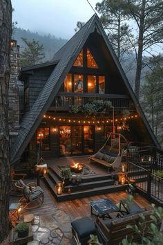 a large cabin with lots of lights on the front porch and deck in the woods