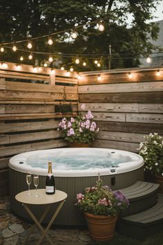 an outdoor hot tub surrounded by flowers and lights