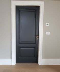 an empty room with a black door and white trim