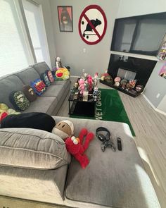 a living room filled with furniture and lots of stuffed animals on top of the couch