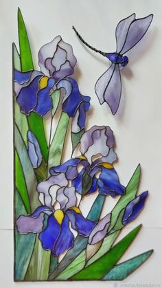 a stained glass panel with blue flowers and a dragonfly on it's back