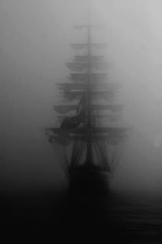 a tall ship sailing in the foggy ocean