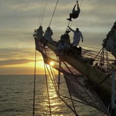 the sun is setting on an old sailing ship