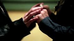 two people are holding hands while one holds the other's hand with their fingers