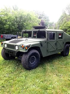 an army green truck parked in the grass