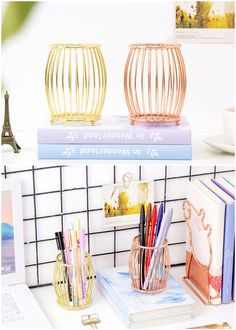 three books are stacked on top of each other with pens and pencils in them