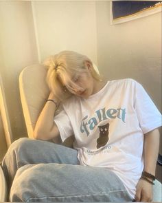 a woman sitting in a chair with her hand on her head while wearing a t - shirt that says fallent