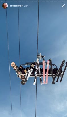 a man riding skis on top of a pair of skis under a blue sky