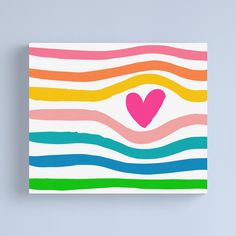 a heart painted on the side of a colorful striped canvas mounted to a blue wall
