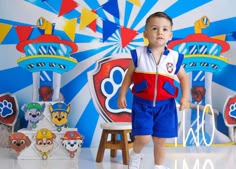a little boy standing in front of a wall with cartoon characters on it's walls