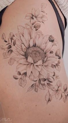 a woman's stomach with a sunflower tattoo on it
