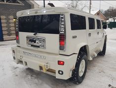 a white hummer is parked in the snow