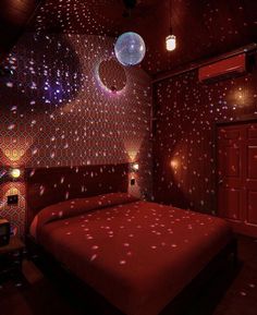 a red bed in a room with disco lights on the walls and ceiling above it