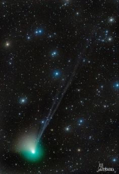 an image of a green object in the sky with stars around it and some blue lights