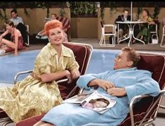 a woman sitting on top of a chair next to a man in a bathrobe