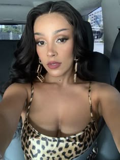 a woman sitting in the back seat of a car with her hand on her hip