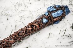 an odd looking object in the snow with chains on it's end and some grass around it