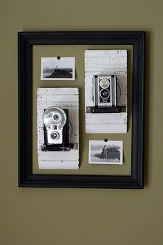 an old fashioned camera mounted to a wall with pictures on the frame and in front of it