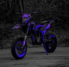 a purple and black dirt bike parked on the street