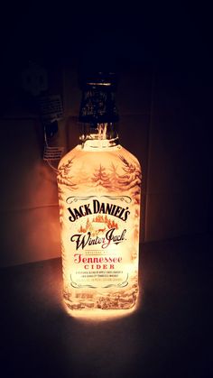 a bottle of jack daniels whiskey sitting on top of a counter next to a light