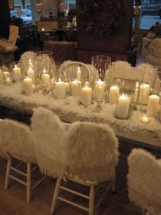 a long table with candles and fur chairs
