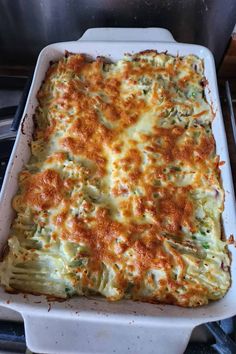 a casserole dish with broccoli and cheese in it on the stove