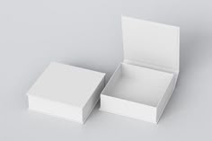 an open white box sitting on top of a gray table next to another empty box