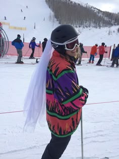 a person on skis in the snow with other skiers behind them at a ski slope