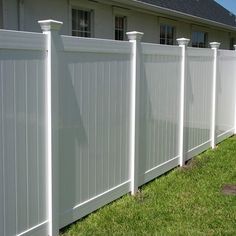 a white vinyl fence in front of a house