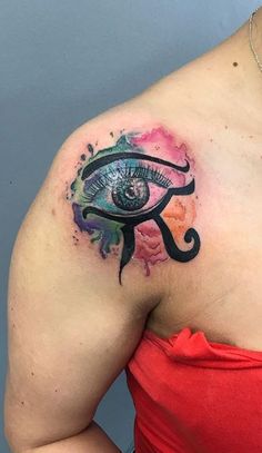 a woman's upper arm with an eye tattoo on her left shoulder and chest