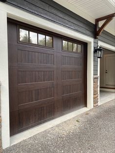 a brown garage door with two windows