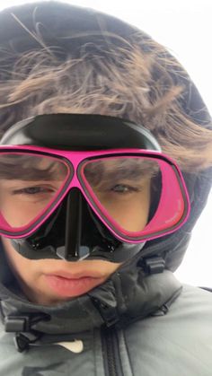 a young boy wearing goggles and a jacket