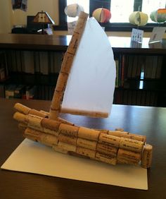 a sailboat made out of wine corks sitting on top of a wooden table
