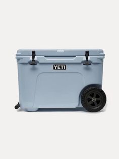 a blue yeti cooler sitting on top of a white floor next to a black wheel