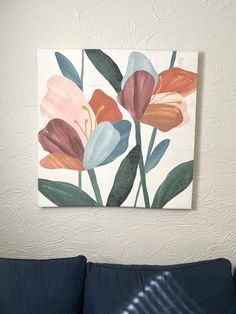 a painting hanging on the wall above a couch