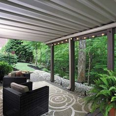 a covered patio with chairs and plants on the side