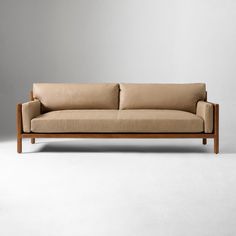 a beige couch sitting on top of a white floor