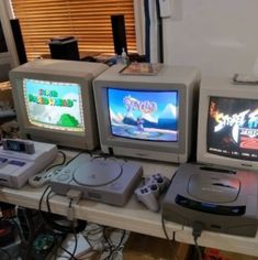 three video game consoles sitting on top of a table
