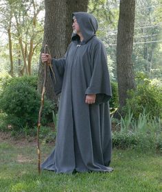 a man in a hooded robe holding a stick