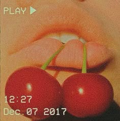 a close up of two cherries on a cell phone