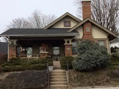 a small house with a chimney on the front and stairs leading up to it's entrance
